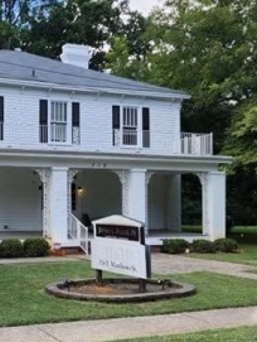 Exterior view of the Funderburk-Plaxco House taken from the left-hand side with trees on both sides of the house.